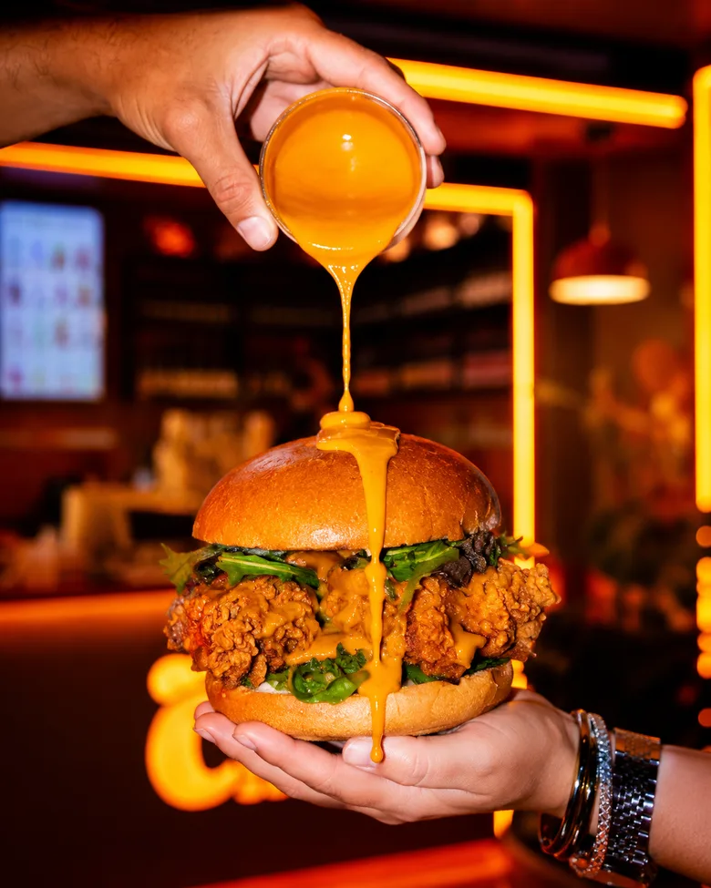 Burger Up de Up Chicken con salsa Up cayendo por encima